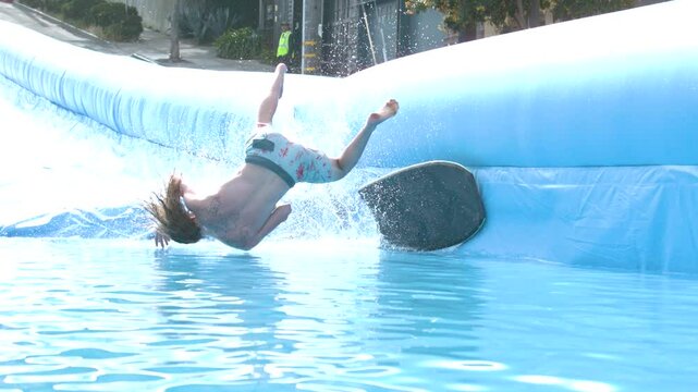 Man falling off board as he slides down massive waterslide in city - super slow motion at 1000 FPS