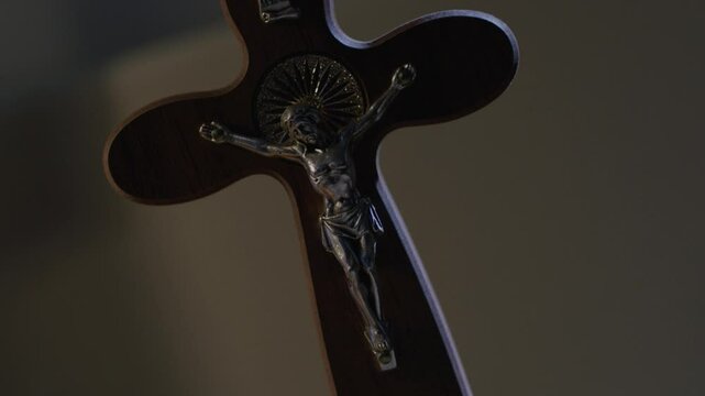 Wooden cross with Jesus in dim light