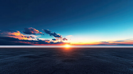 Serene open desert plain under fading orange and blue sky, with sun setting on horizon and scattered clouds adding depth to tranquil scene