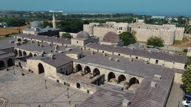 A bird's eye view of the Payas Sokullu Mehmet Pasha Complex! Located in a region with a natural harbor, this group of buildings draws attention with the old castle and harbor seen in the background.