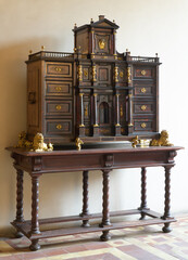 Architectural cabinet with twisted legs, gilded lion figures, and inlaid drawers, displayed in...