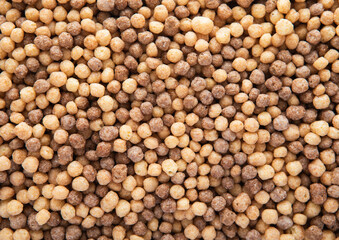 Mini peanut butter and chocolate puffs breakfast cereal textured macro shot.Top view.