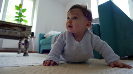 Baby on the floor, pushing up with arms, looking ahead with curiosity, actively exploring...