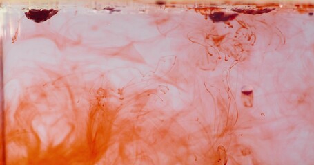 Abstract background. Red paint falls into the water