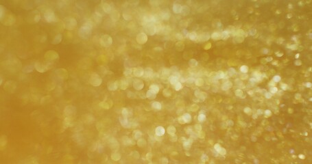 Abstract background. The golden sequins are bubbling and shimmering. Blurred boho sequins