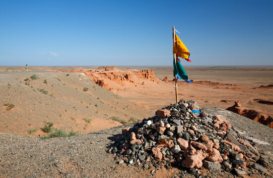 Ritual place obo overlooking erosion formations at Bayanzag flaming cliffs, Gobi desert, Mongolia