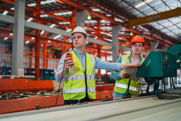 Fototapeta premium Working in a factory with modern industrial machines, engineers operate equipment with precision and safety, showcasing teamwork, efficiency, and dedication in a well-structured production environment