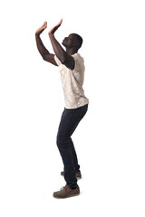 side view of a standing man holding or pushing something imaginary upwards.