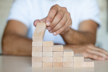 Hand arranging wood block stacking as step stair.