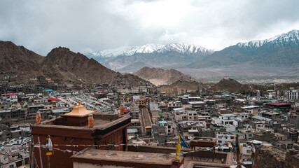 A scenic view of Leh town nestled in the rugged Himalayas, surrounded by dramatic brown mountains...