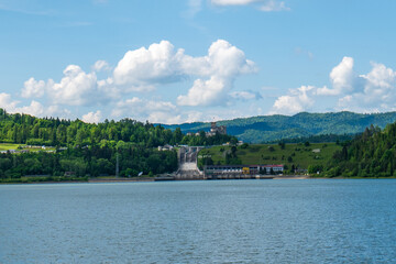 Hydroelectric dam and power station near Niedzica Castle in southern Poland, surrounded by forested...