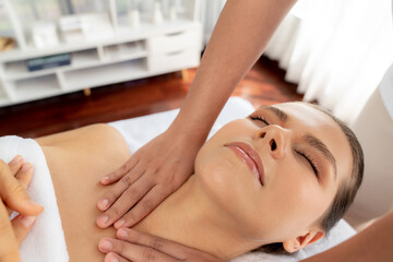 Caucasian woman customer enjoying relaxing anti-stress spa massage and pampering with beauty skin recreation leisure in day light ambient salon spa at luxury resort or hotel. Quiescent