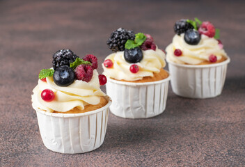 Homemade cupcakes decorated with cream cheese and berries