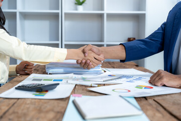 Business Handshake Over Financial Documents