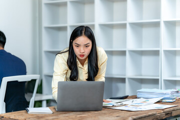 Focused Asian Woman Working on Laptop