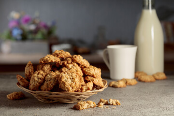 Oatmeal cookies and milk on a kitchen table.