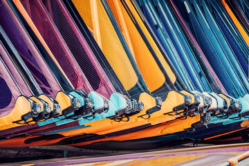 Windsurfing equipment rental or store with colorful sails is waiting for tourists on a sunny beach