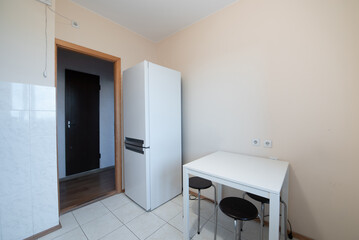 Minimalist Home Kitchen Corner Featuring Refrigerator and Compact Dining Table with Stools