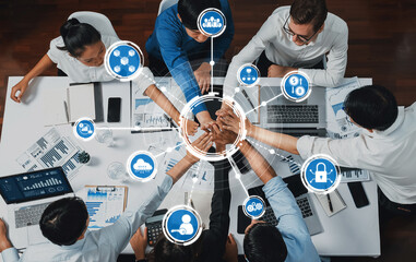 A diverse business team members collaborate around a modern workspace, engaging in strategy...