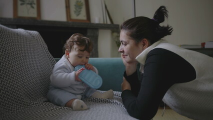 Fototapeta premium Mother gently leaning towards baby, sharing intimate and playful moment during bonding, encouraging early childhood communication and exploration, nurturing home environment
