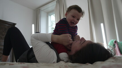 Mother holding crying baby in bed, comforting and soothing during emotional moment, showing...