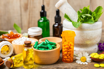 Alternative medicine herbal capsule organic drug on wooden background.Assortment of herbal and...