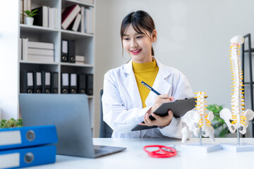 Smiling Doctor Examining Spinal Model