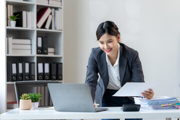 Smiling Asian Businesswoman Working at Desk © Kritdanai