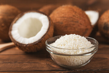 Set of fresh whole and half coconuts and slices on wooden background. Coconut flakes. Vegan. Tropical nut, fruit. Place for text. Copy space.