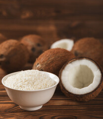 Set of fresh whole and half coconuts and slices on wooden background. Coconut flakes. Vegan....