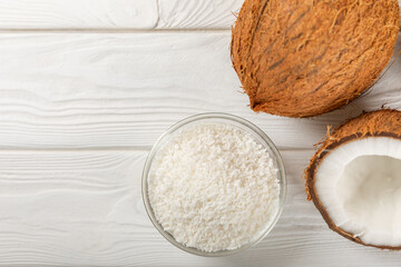 Set of fresh whole and half coconuts and slices on wooden background. Coconut flakes. Vegan. Tropical nut, fruit. Place for text. Copy space.