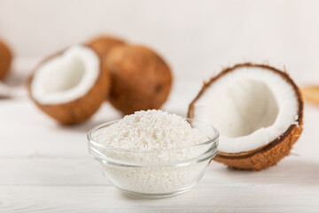 Set of fresh whole and half coconuts and slices on wooden background. Coconut flakes. Vegan. Tropical nut, fruit. Place for text. Copy space.