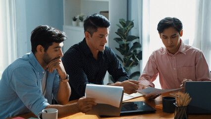 Executive manager explain financial graph to colleague at meeting room. Top aerial view of diverse marketing team sharing idea and planning strategy while sitting at table with tablet. Convocation.