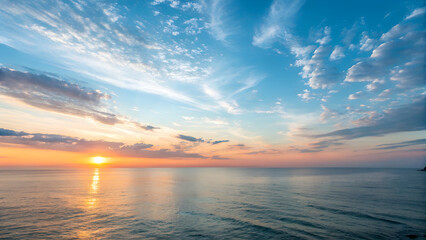 Serene ocean sunset with vibrant sky colors and fluffy clouds reflecting on calm water ideal for travel and nature themes.