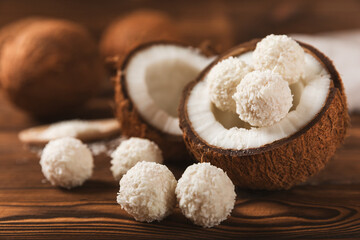Coconut candies on a wooden background. Candies with chocolate, almonds and delicate butter cream. Coconut flakes. tasty sweets.Tasty ball-shaped chocolate candies.Dessert. Space for text.copy space