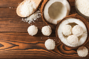 Coconut candies on a wooden background. Candies with chocolate, almonds and delicate butter cream. Coconut flakes. tasty sweets.Tasty ball-shaped chocolate candies.Dessert. Space for text.copy space