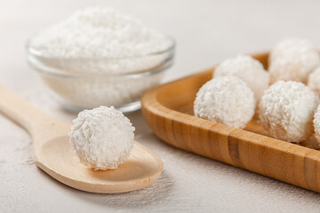 Coconut candies on a wooden background. Candies with chocolate, almonds and delicate butter cream. Coconut flakes. tasty sweets.Tasty ball-shaped chocolate candies.Dessert. Space for text.copy space
