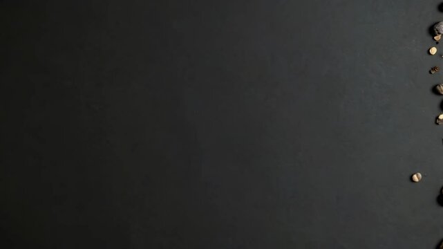 Dark background with assorted nuts, dried fruits and seeds around right edge, creating a food border with open space for text or graphics.