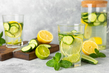 Cucumber water with lemon, lime and mint on a wooden table. Water infused with sliced...