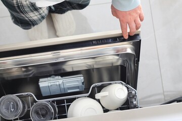 Kitchen appliance in action as person uses dishwasher to clean dishes after meal preparation in...