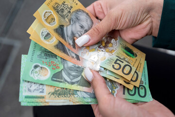 woman count new 50 100 australian currency on a city street. AUD Saving concept
