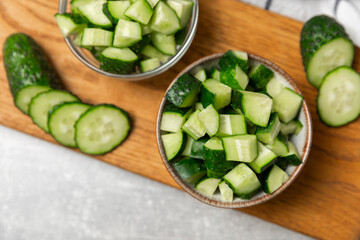 Cucumber on wooden background. Slice of cucumber on background. Fresh organic green cucumbers gherkin. Vegan. Salad ingredient. Farm vegetables. Cut vegetables with knife. Space for text. Copy space