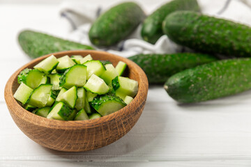 Cucumber on wooden background. Slice of cucumber on background. Fresh organic green cucumbers gherkin. Vegan. Salad ingredient. Farm vegetables. Cut vegetables with knife. Space for text. Copy space
