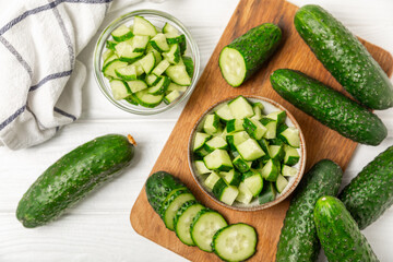 Cucumber on wooden background. Slice of cucumber on background. Fresh organic green cucumbers gherkin. Vegan. Salad ingredient. Farm vegetables. Cut vegetables with knife. Space for text. Copy space