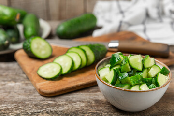 Cucumber on wooden background. Slice of cucumber on background. Fresh organic green cucumbers gherkin. Vegan. Salad ingredient. Farm vegetables. Cut vegetables with knife. Space for text. Copy space