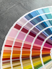  catalog of paints with different samples on grey desk.  Rainbow sample colors catalogue.
