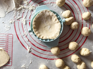 raw dough balls for dumplings kluski slaskie on flour on kitchen desk