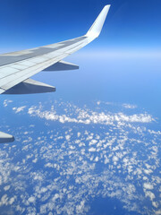 Fototapeta premium Coastal aerial view from airplane window flying above deep blue sea