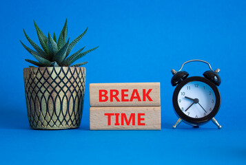 Break Time symbol. Wooden blocks with words Break Time. Beautiful blue background with alarm clock...