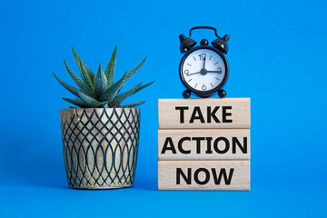 Take action now symbol. Wooden blocks with words Take action now. Beautiful blue background with...